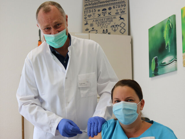 Dr. Matthias Keilen, Vorstand Medizin, impft während der Corona-Pandemie eine Mitarbeitende 