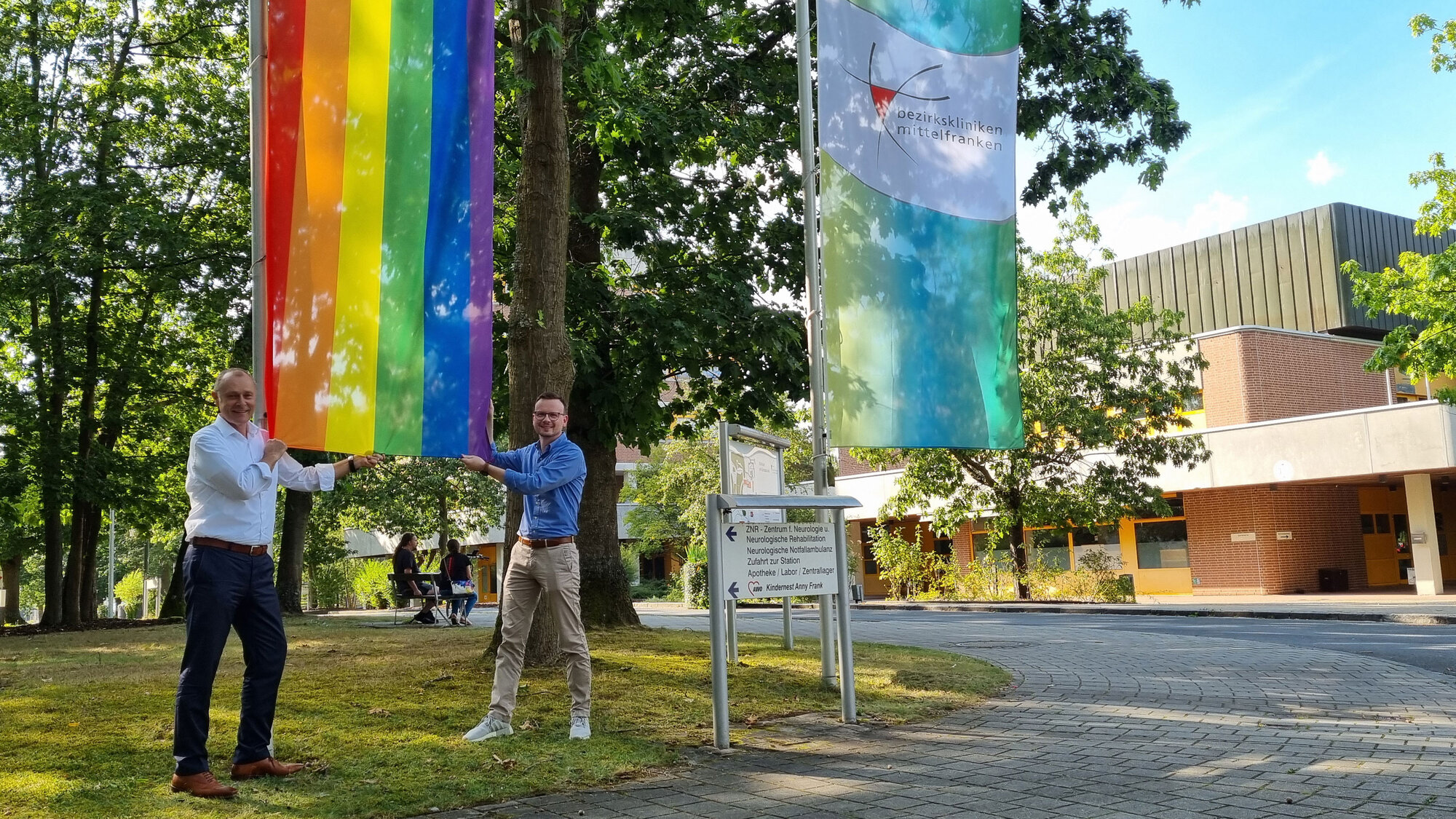 Dr. Matthias Keilen, Vorstand Medizin und Peter Daniel Forster, Bezirkstagspräsident und Vorsitzender des Verwaltungsrats, hissen die Regenbogenflagge am Klinikum am Europakanal