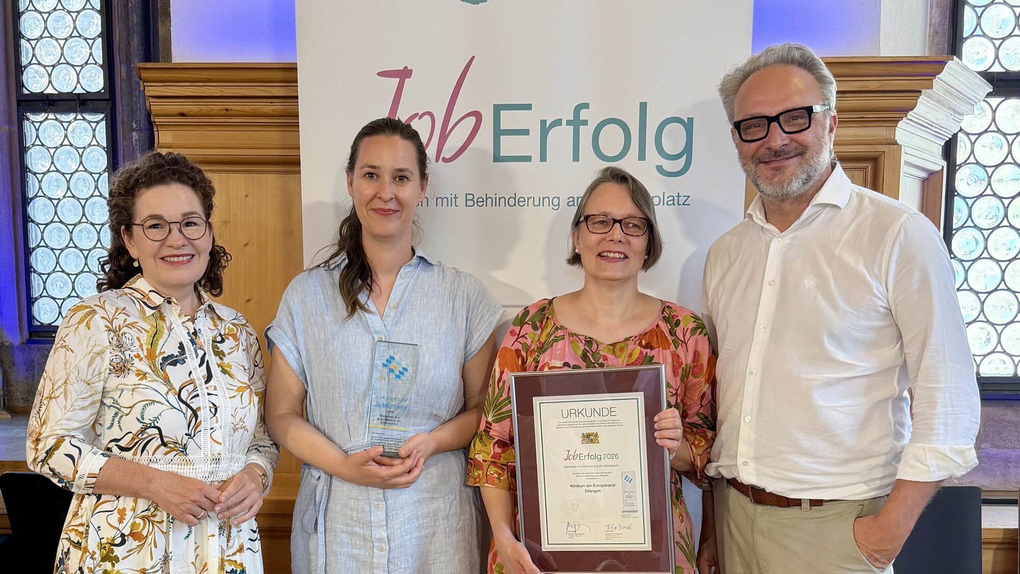 Stinne Fronius, Kaufmännische Vorständin der Bezirkskliniken Mittelfranken, Dr. Jenny Unseld, Assistenzärztin am Klinikum am Europakanal, Birgit Schuppener, Inklusionsbeauftragte der Bezirkskliniken Mittelfranken, und Dr. Ulrich Kastner, Chefarzt am Klinikum am Europakanal, beim Festakt zum Inklusionspreis JobErfolg 2026 im Historischen Rathaussaal in Nürnberg.