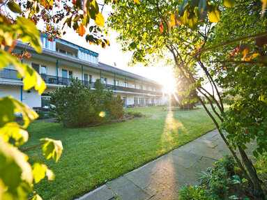 Außenansicht Sozialpsychiatrische Einrichtung Eggenhof, zweistöckiges Gebäude im Grünen gelegen, bei Sonnenuntergang