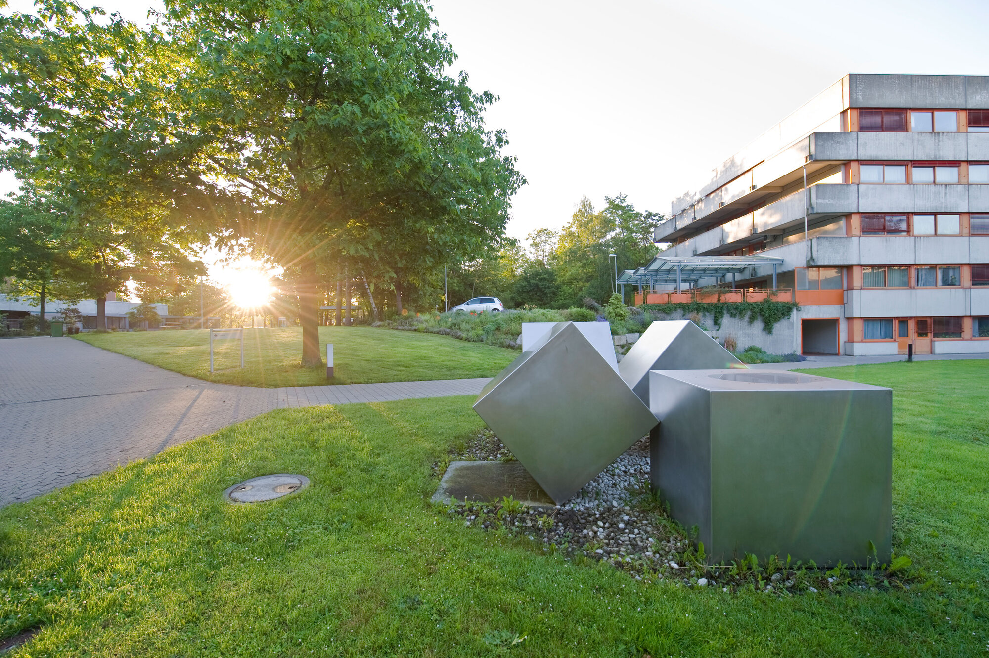 Außenansicht des Gebäudes A des Klinikums am Europakanal bei Sonnenuntergang, mehrstöckiges Gebäude, Betonfassade mit roten Metallelementen