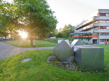 Außenansicht des Gebäudes A des Klinikums am Europakanal bei Sonnenuntergang, mehrstöckiges Gebäude, Betonfassade mit roten Metallelementen