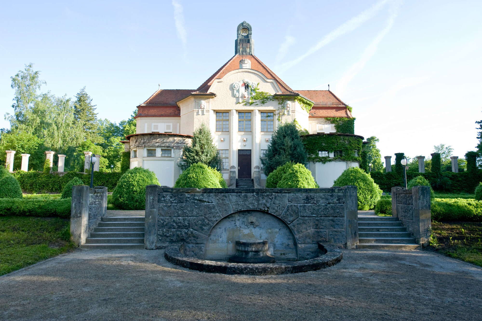Außenansicht Festsaal, ein Gebäude im Jugendstil, mit Treppenanlage und kleinem Park auf dem Gelände des Bezirksklinikums Ansbach