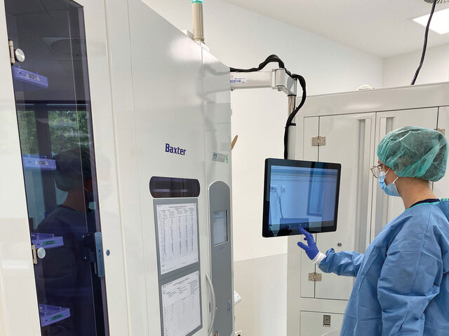 Mitarbeitende in der Apotheke bedient den Blisterautomat