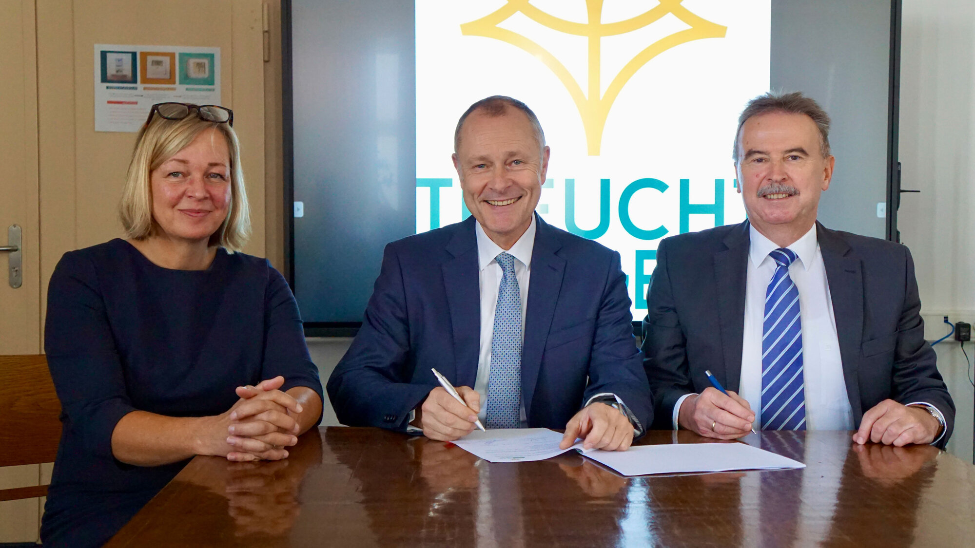 Dr. Matthias Keilen sowie zwei Mitarbeitende der Stadtwerk Treuchtlingen bei der Vertragsunterzeichnung